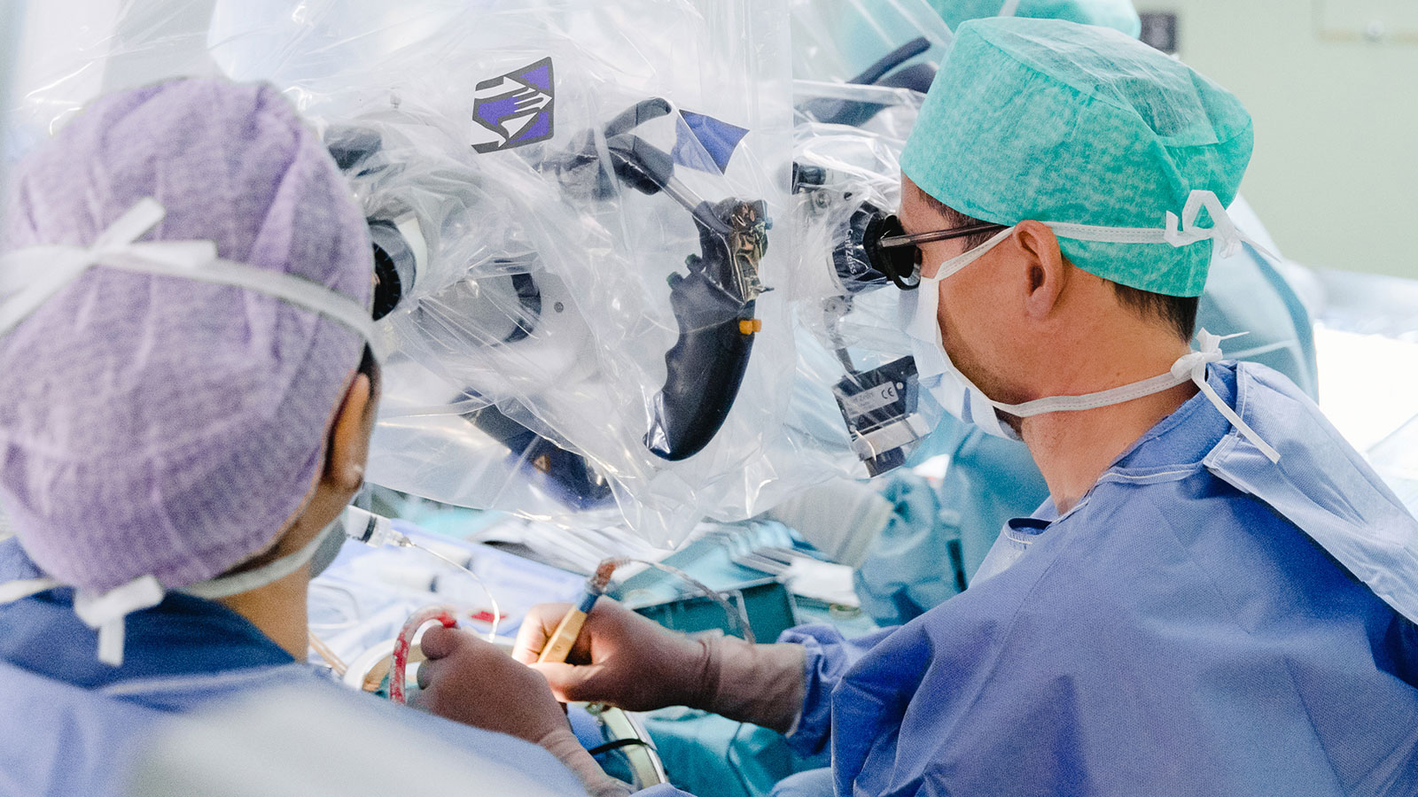 Photo of neurosurgeon operating with the aid of a surgical microscope